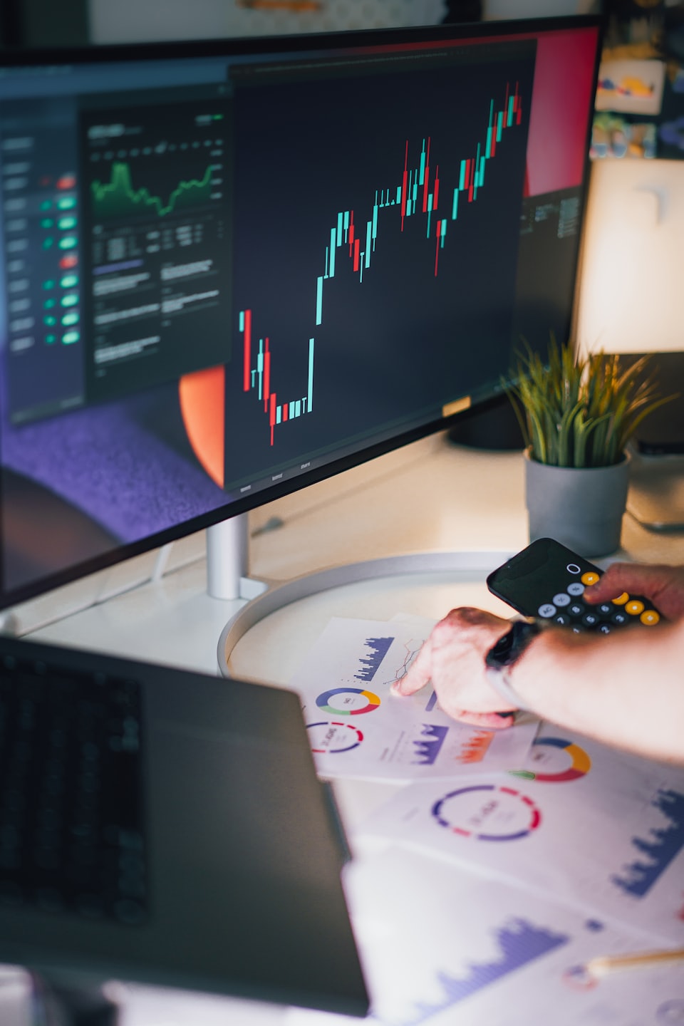 Osoba analyzuje grafy finančných údajov na bielom stole.